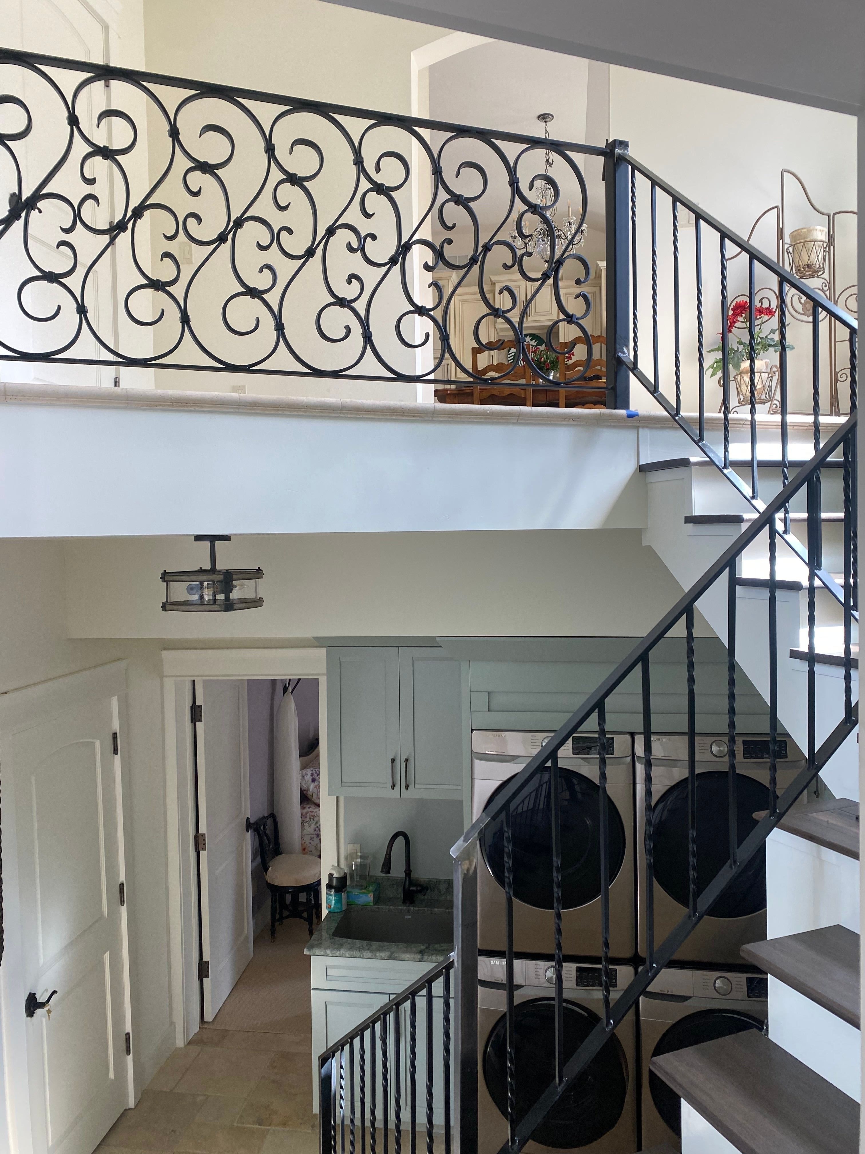 Interior staircase railing with hand-forged balusters and bronze patina